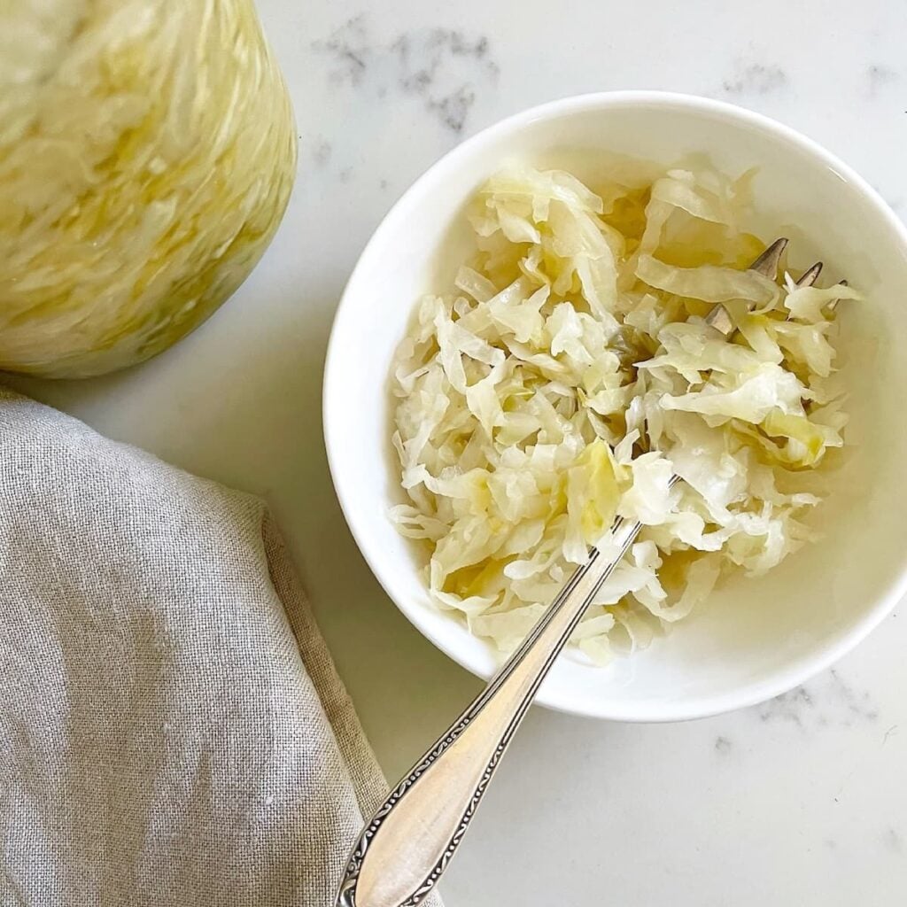 small bowl with sauerkraut and fork on kitchen counter