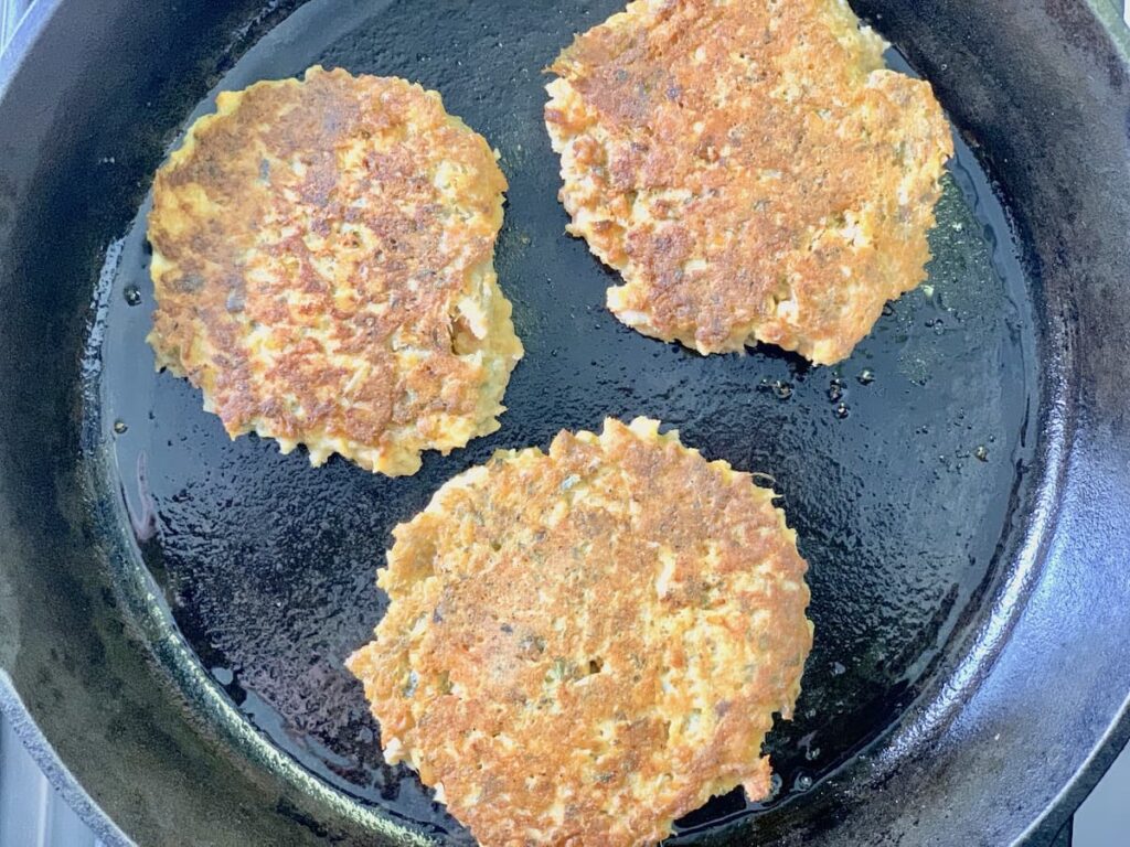 cooked salmon patties in cast iron skillet