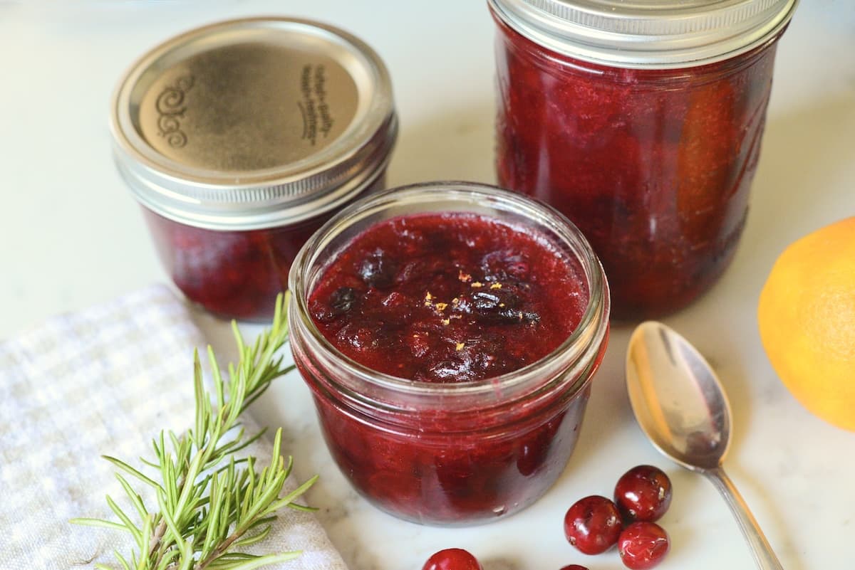 3 glass jars filled with homemade cranberry compote.