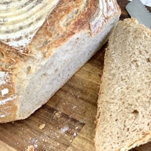 loaf of bread with slices on cutting board