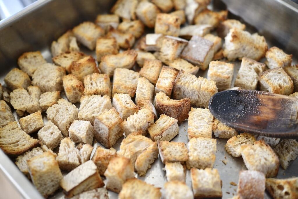 roasted bread cubes in stainless steel casserole dish