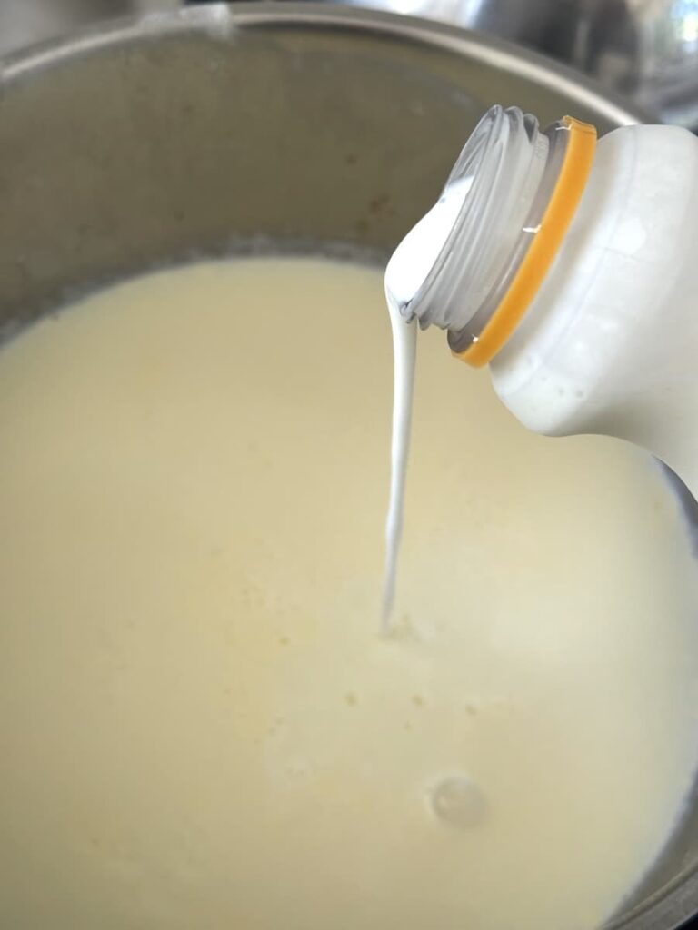 buttermilk pouring into pot with milk