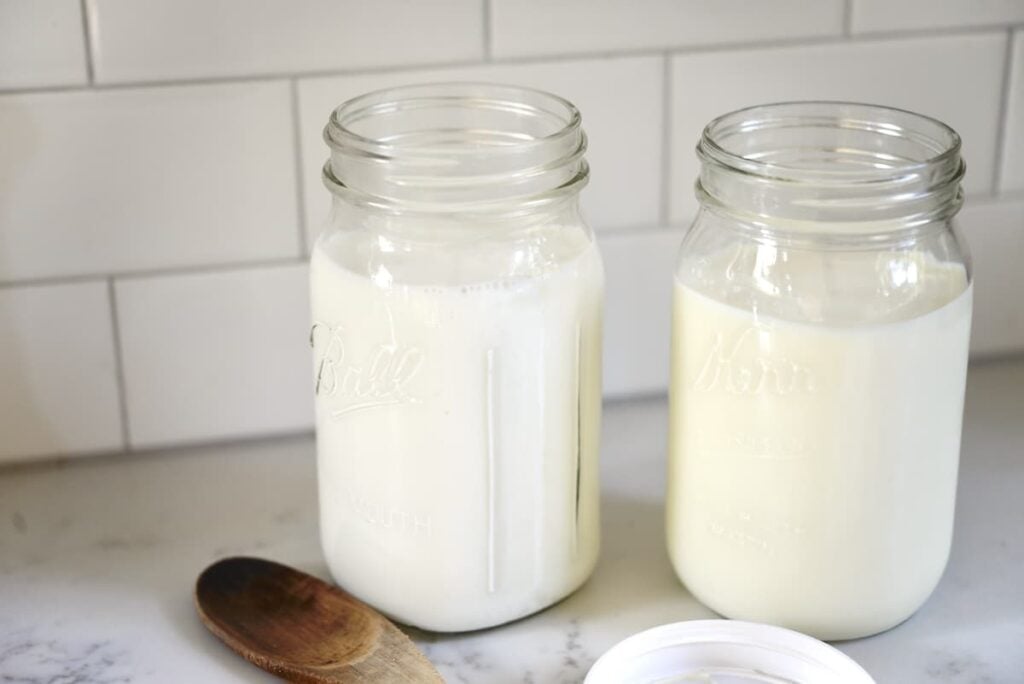 2 large mason jars with milk on kitchen counter