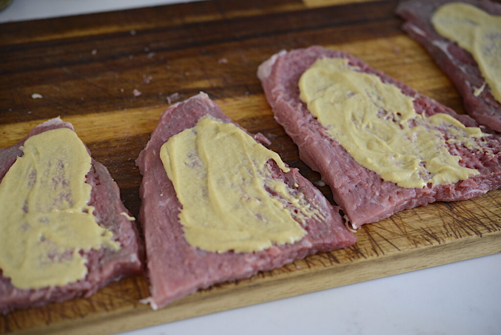 mustard spread on meat slices