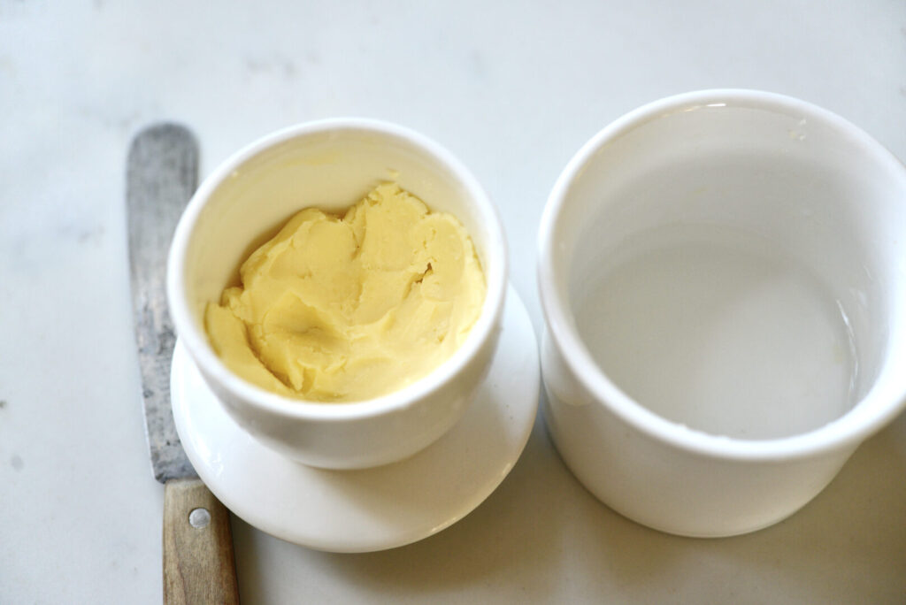 butter bell with butter and knife next to it