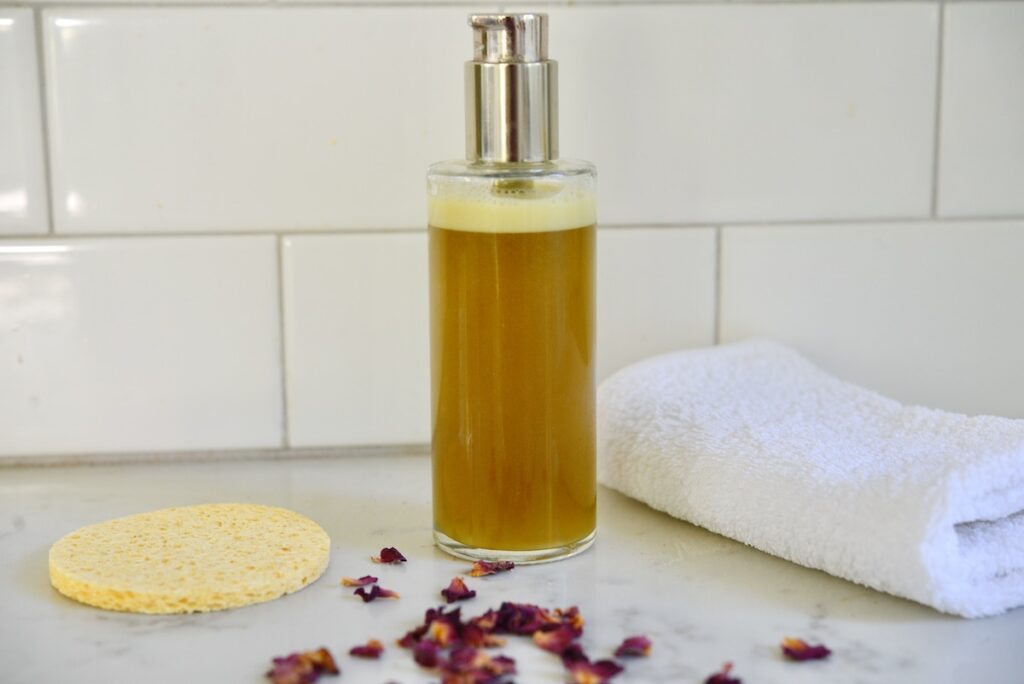 herbal face wash with sponge, rose petals, and towel