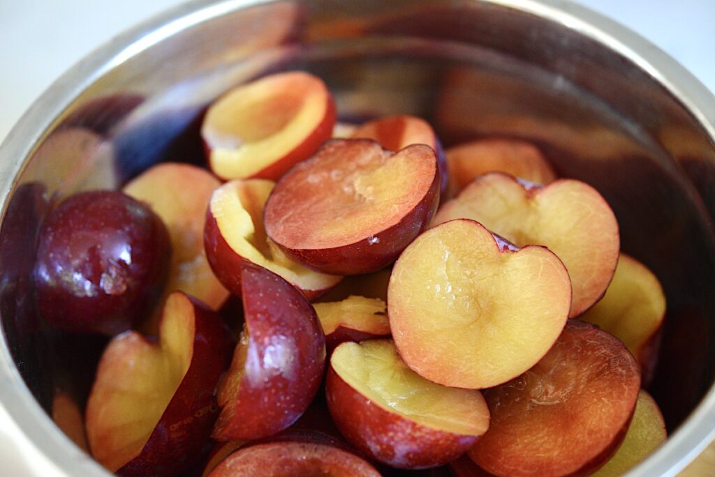 bowl with pitted and halved plums