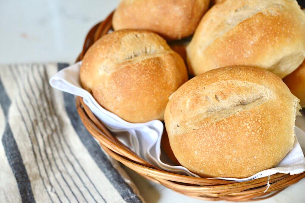 crusty German bread rolls in basket with towel