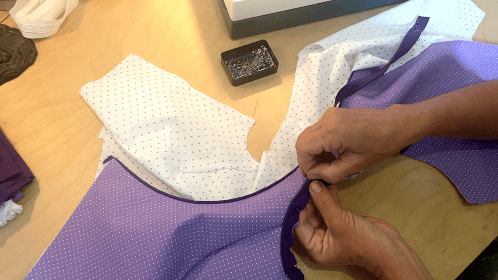 attaching piping to the armholes of the bodice