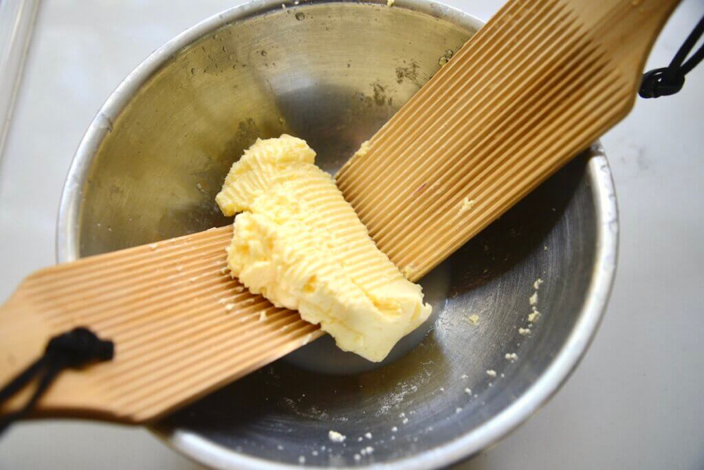 butter paddles in a bowl with cultured butter