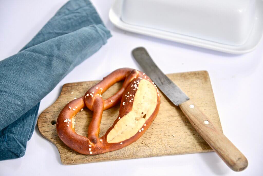 German pretzel with knife on cutting board 