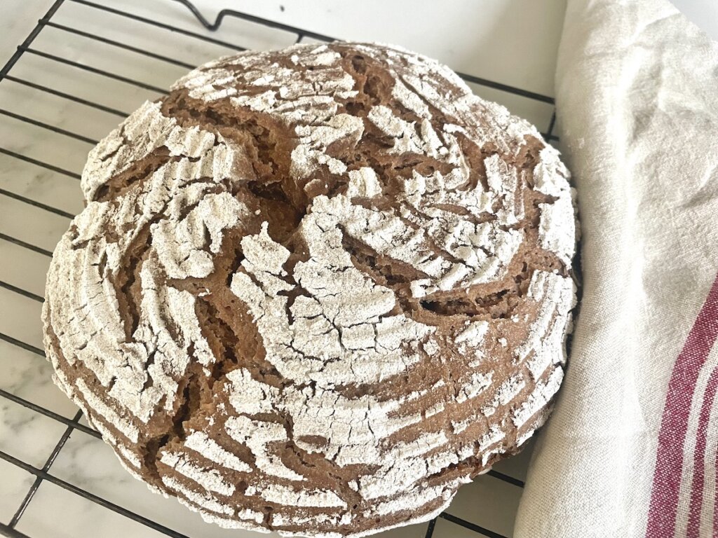 sourdough bread on rack with towel