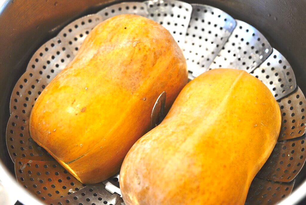 butternut squash halves in stainless steel steamer basket