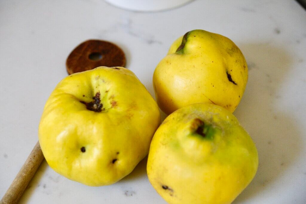 3 quince on counter with wooden spoon