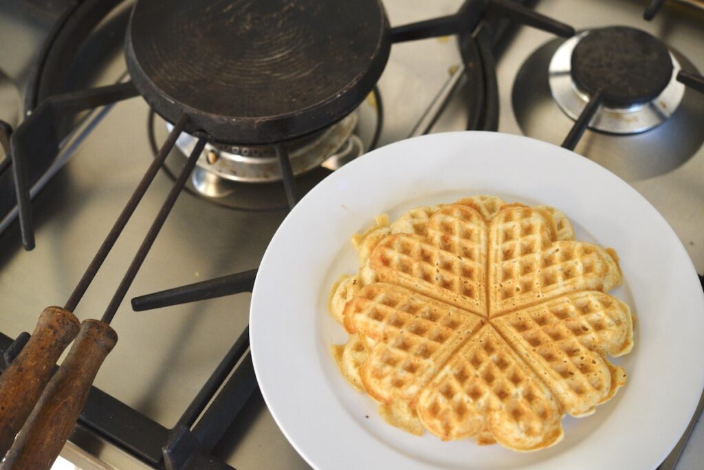 sourdough waffles on plate with cast iron waffle maker