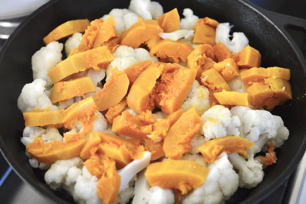 cooked cauliflower and pumpkin in cast iron skillet