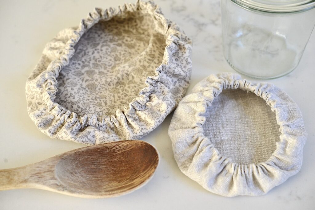 reusable bowl covers on kitchen counter with jar and spoon