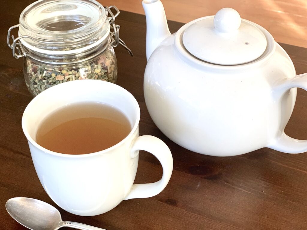 teacup, teapot and herbal tea on table
