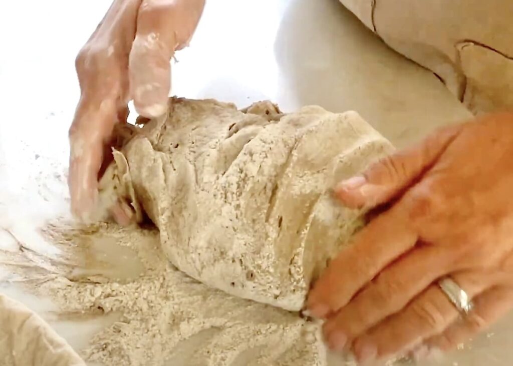 hands shaping sticky dough into ball