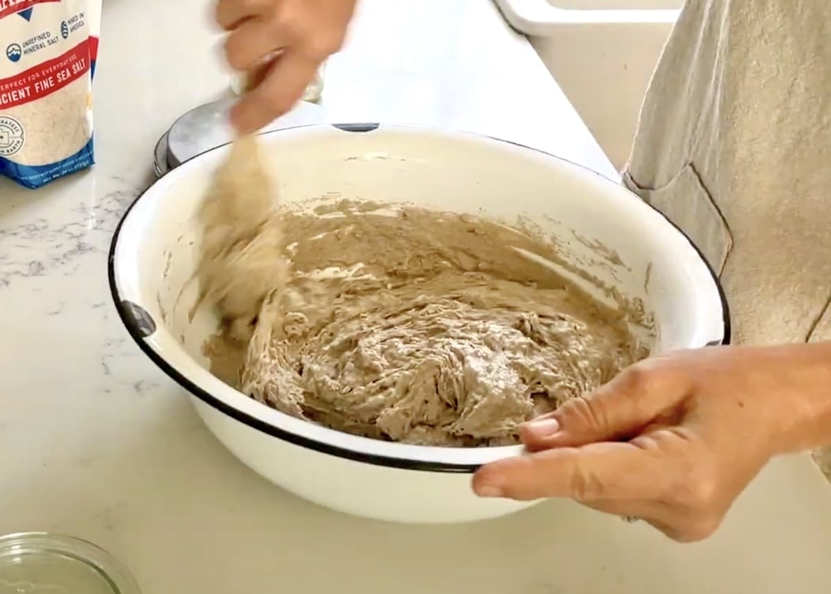 hand mixing sticky dough in bowl