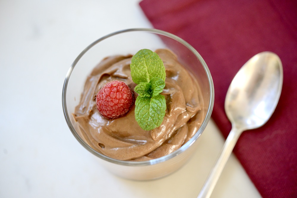 avocado chocolate mousse in glass with spoon and napkin