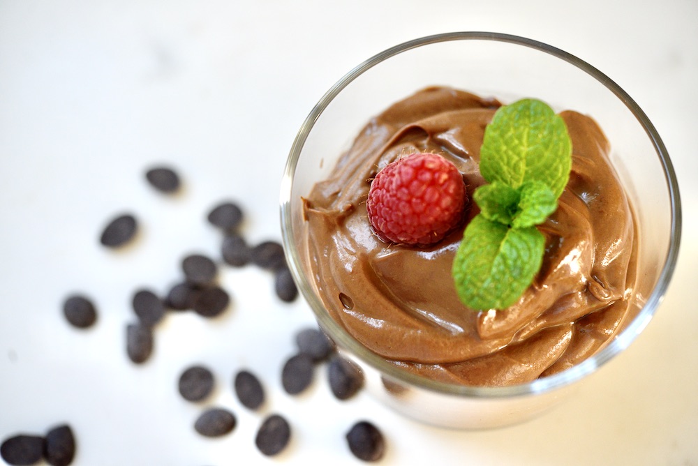 avocado chocolate mousse in glass with raspberry and mint leaves 