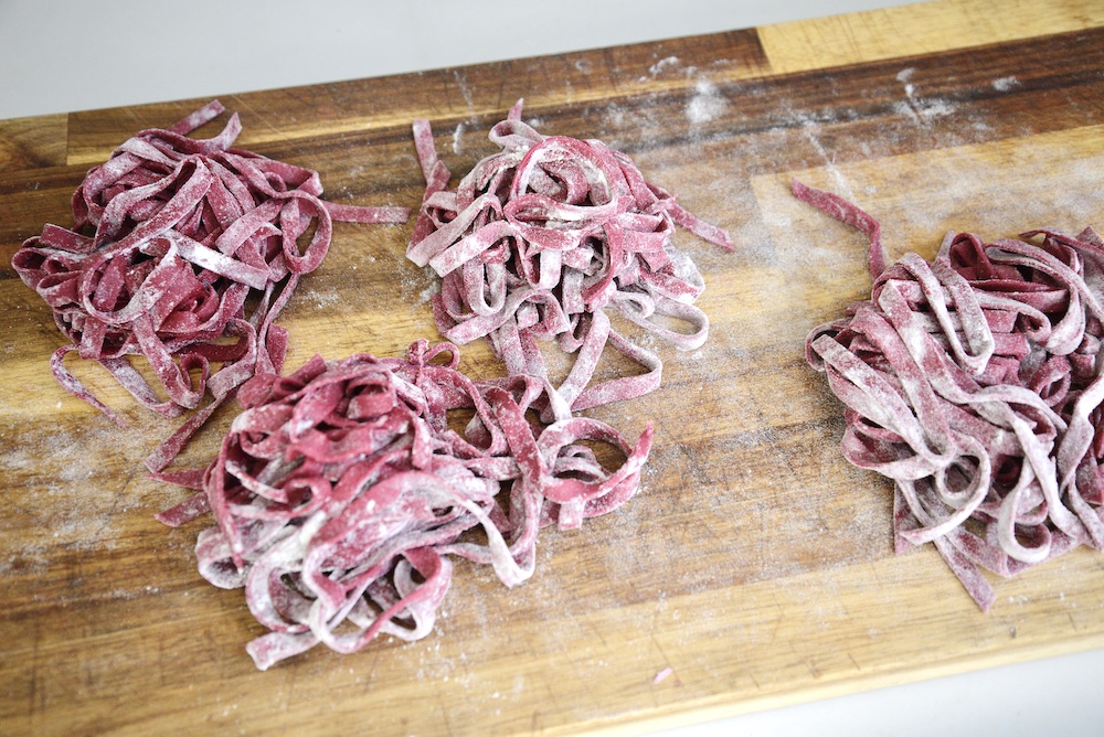 floured beet pasta on cutting board