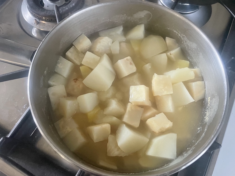 cooked celery root and potato in saucepan
