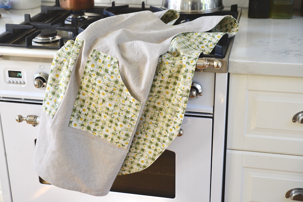 reversible apron laid out on stove in kitchen