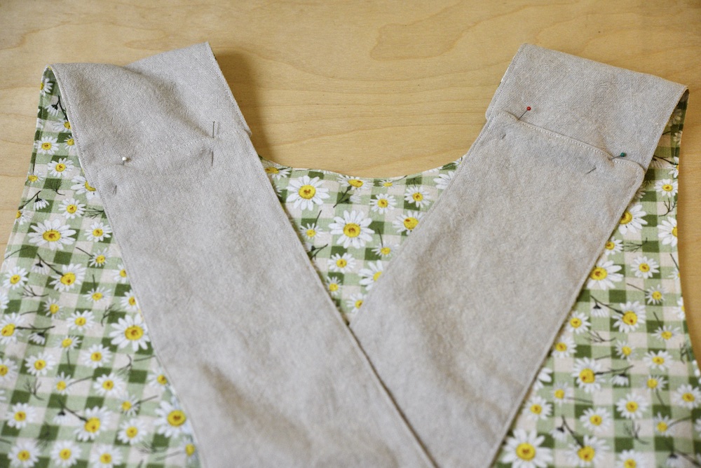 reversible apron with the straps crossed and pinned together