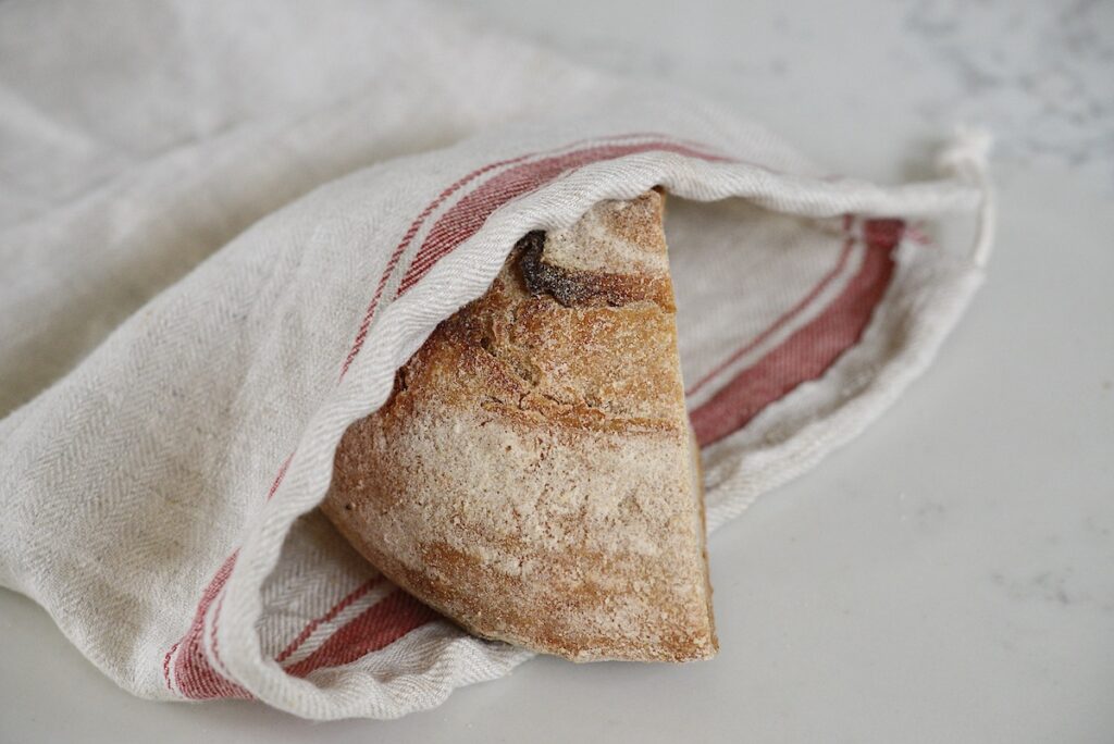 half loaf of bread in a linen bread bag