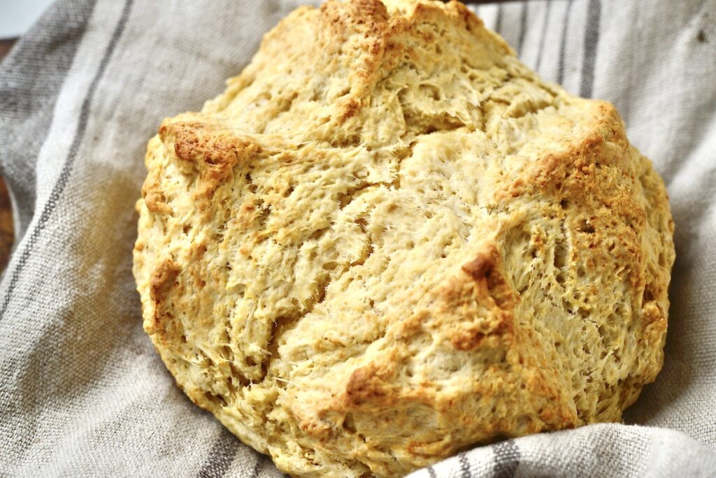 loaf of sourdough Irish soda bread on kitchen towel