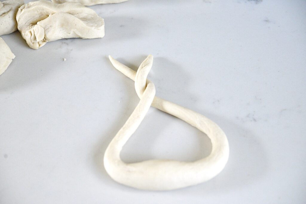 dough roll with both ends twisted on kitchen counter