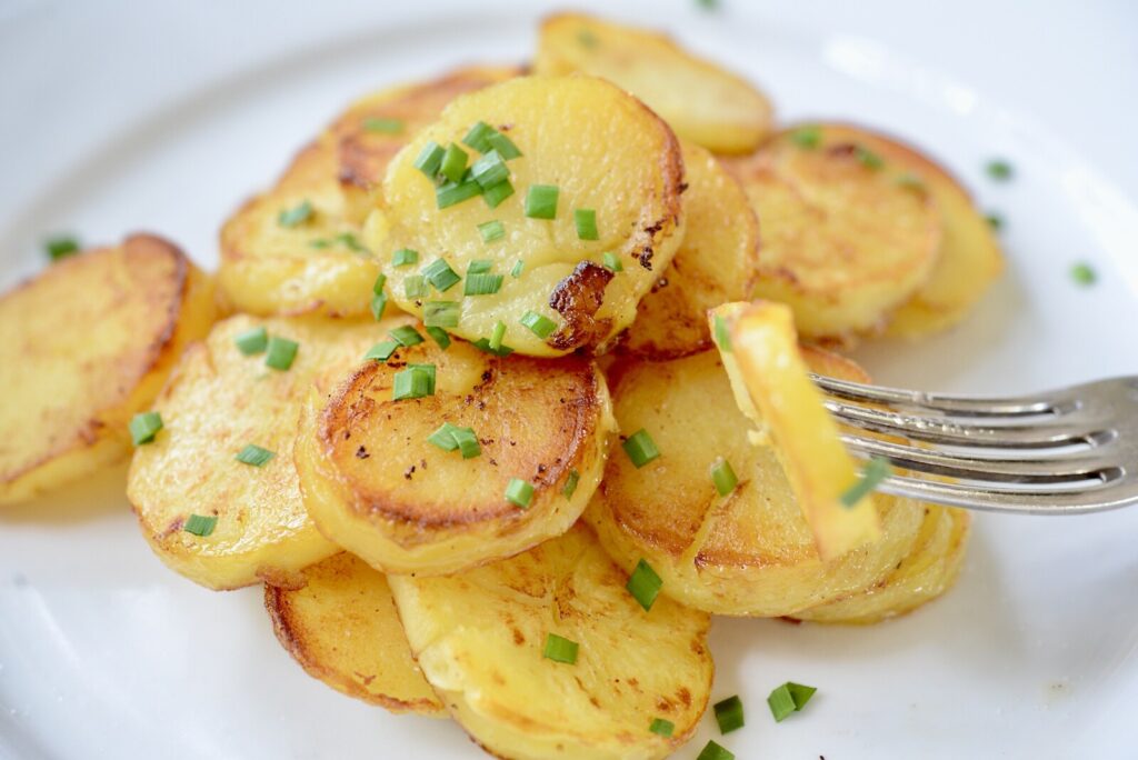 fried potatoes on plate with fork