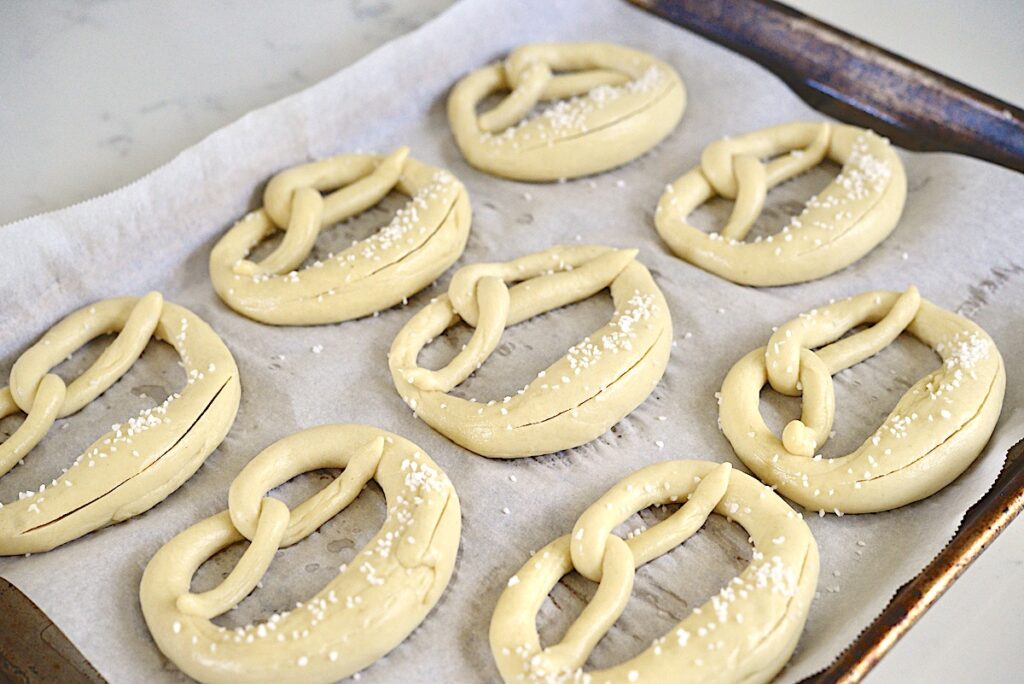 unbaked pretzels on baking tray lined with parchment paper
