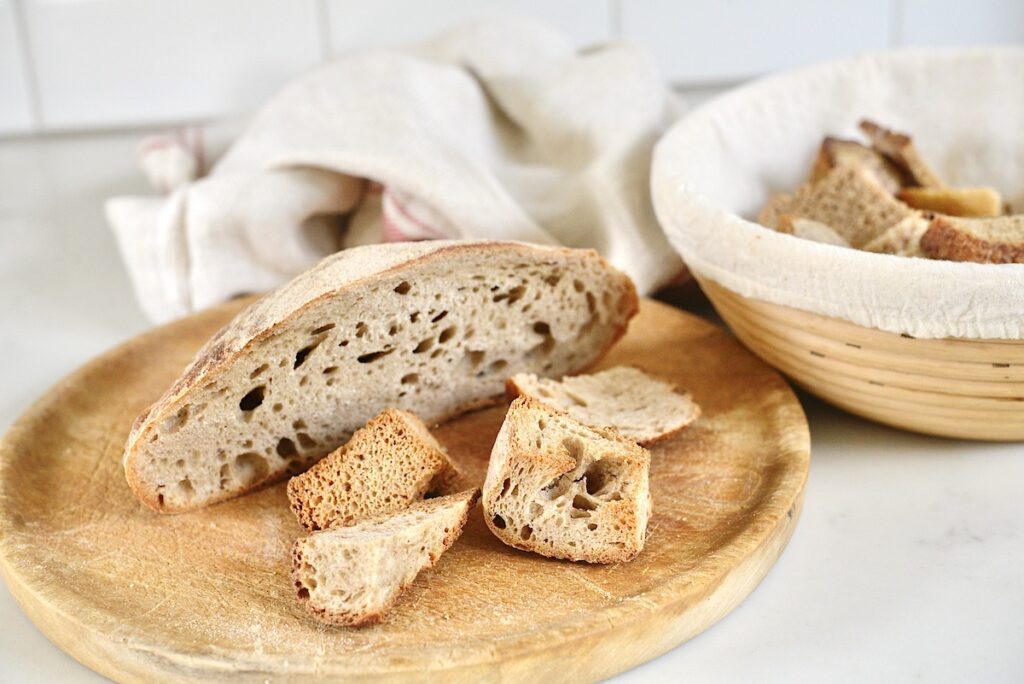 pieces of stale bread on wooden cutting board and in bread basket