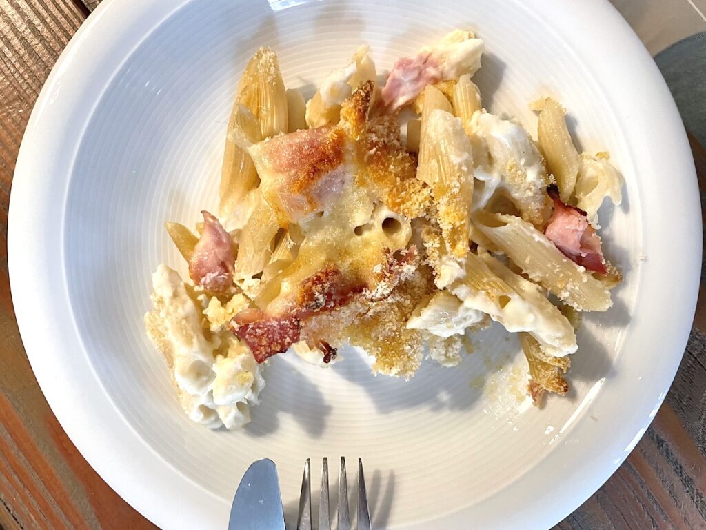 noodle casserole with breadcrumbs topping on white plate