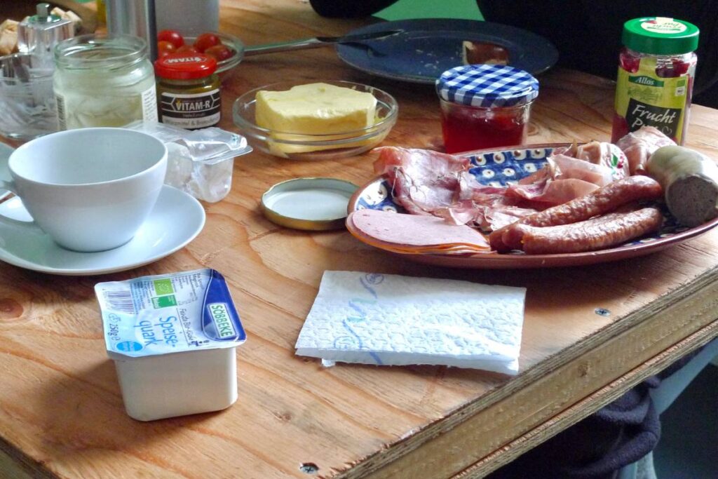German breakfast table with cold cuts, cup with saucer, butter, and jams