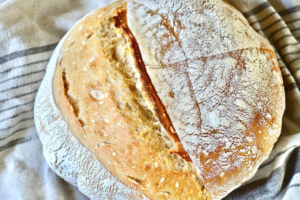 loaf of sourdough bread on kitchen towel