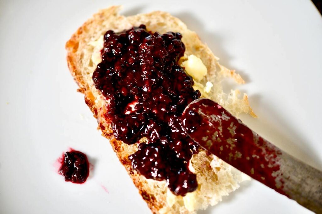 elderberry spread on a slice of bread with knife