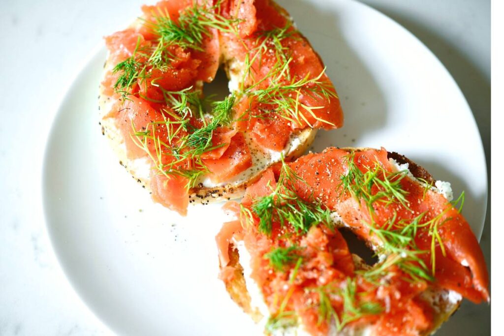 smoked salmon with dill on bagels on white plate