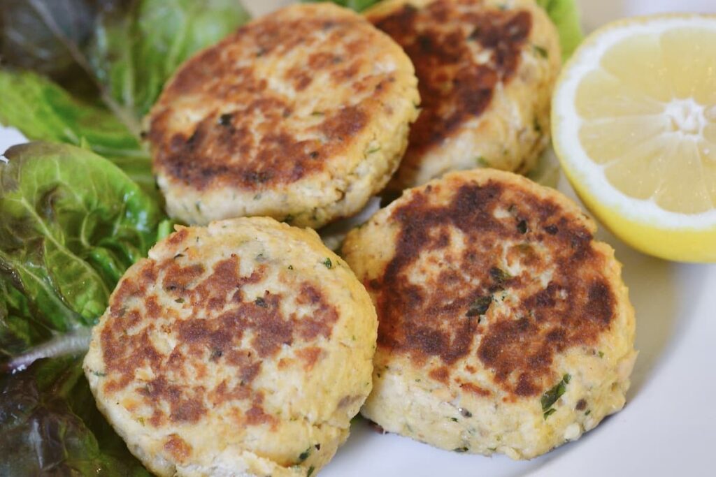 salmon cakes on plate with lettuce and lemon
