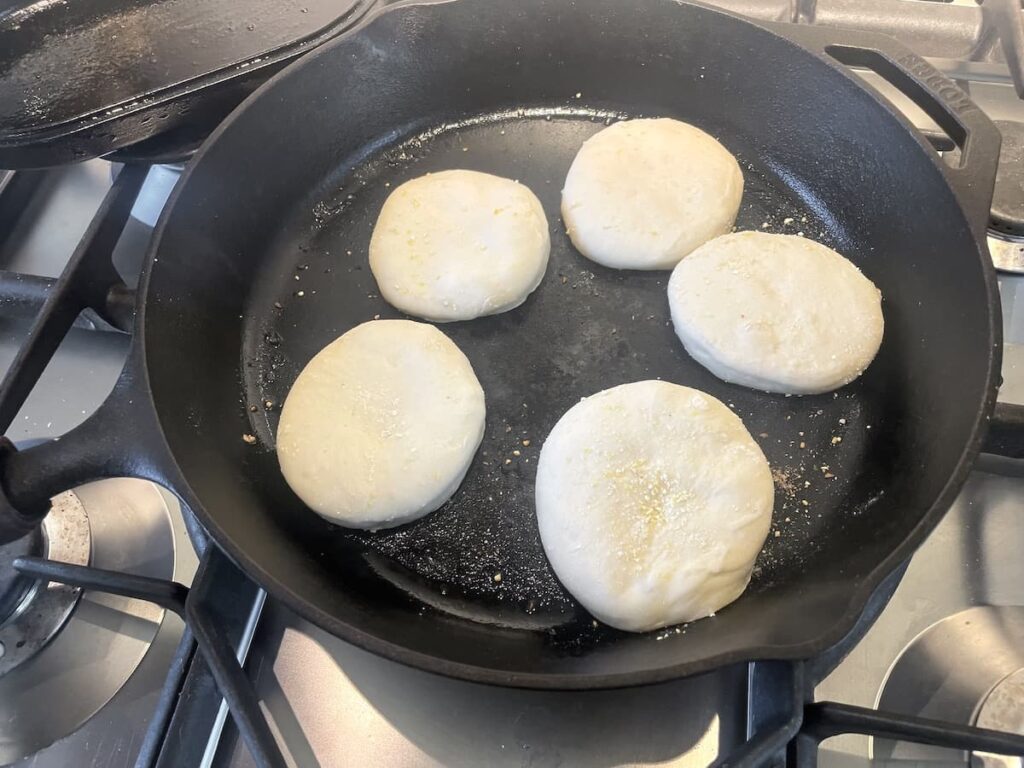 sourdough English muffins in cast iron skillet