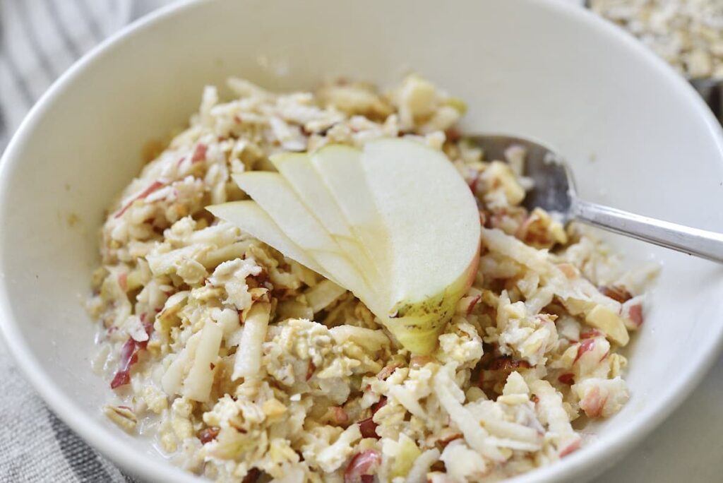 bowl of Bircher muesli with apple slices and spoon