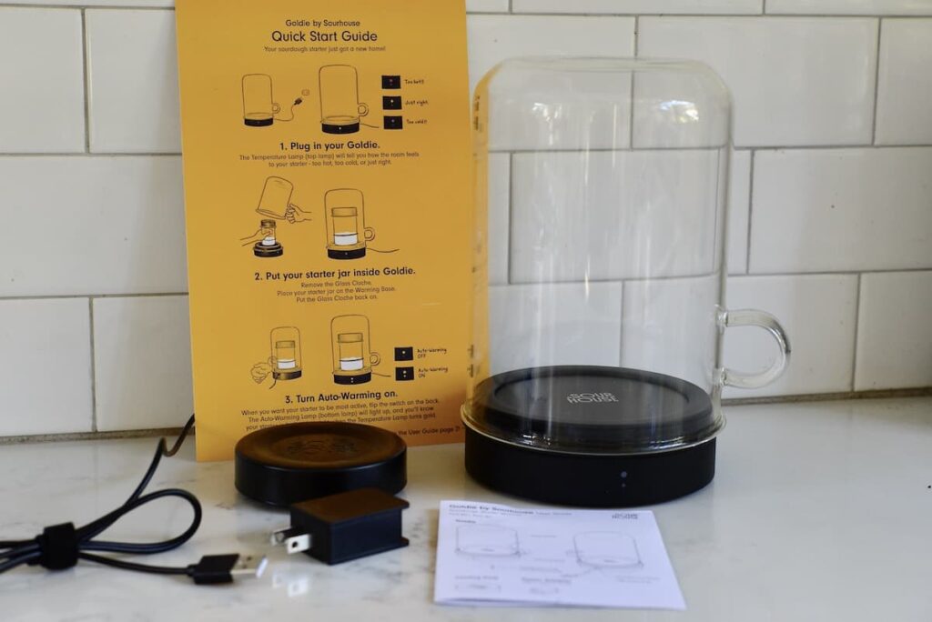 Sourhouse Goldie with quick start guide, cooling puck, power adapter, and user guide on kitchen counter
