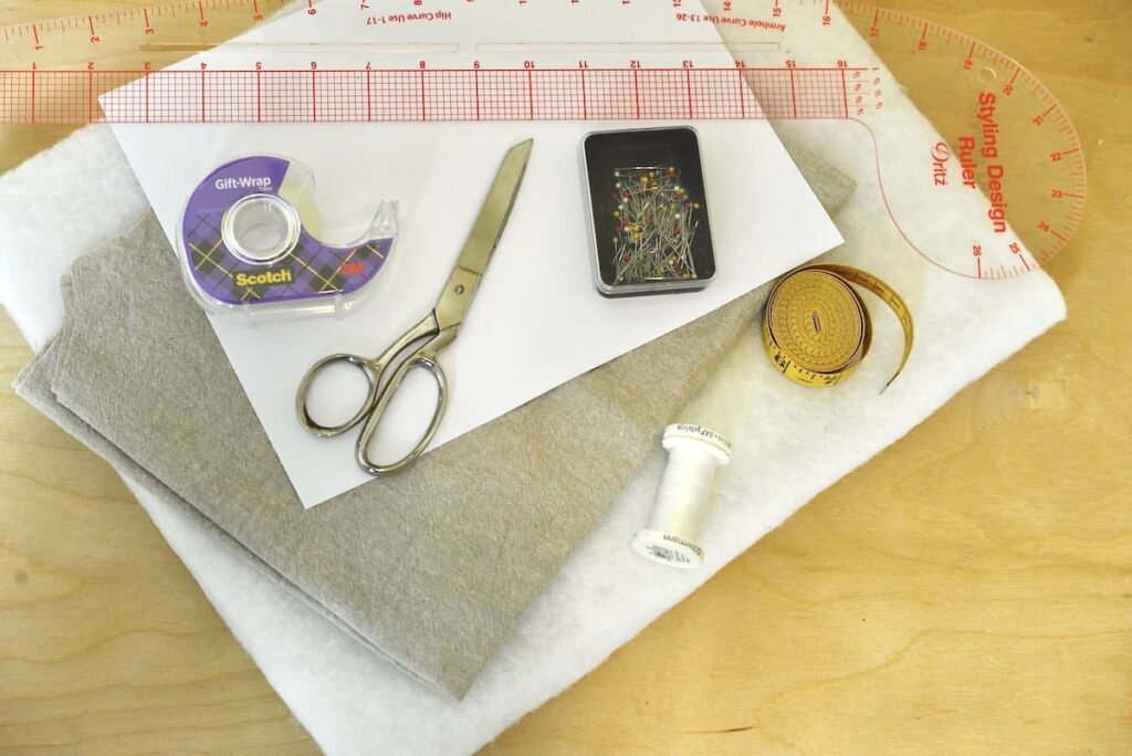 batting, fabric, scotch tape, scissors, sewing pins, thread, measuring tape, and curved ruler