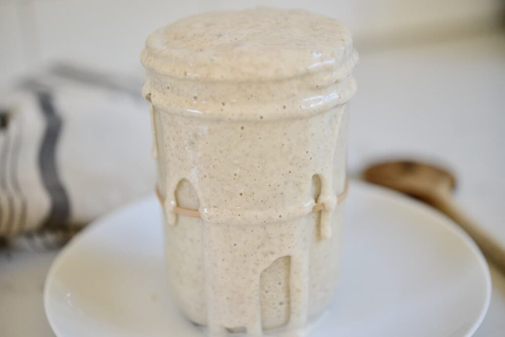 sourdough starter flowing out of glass jar