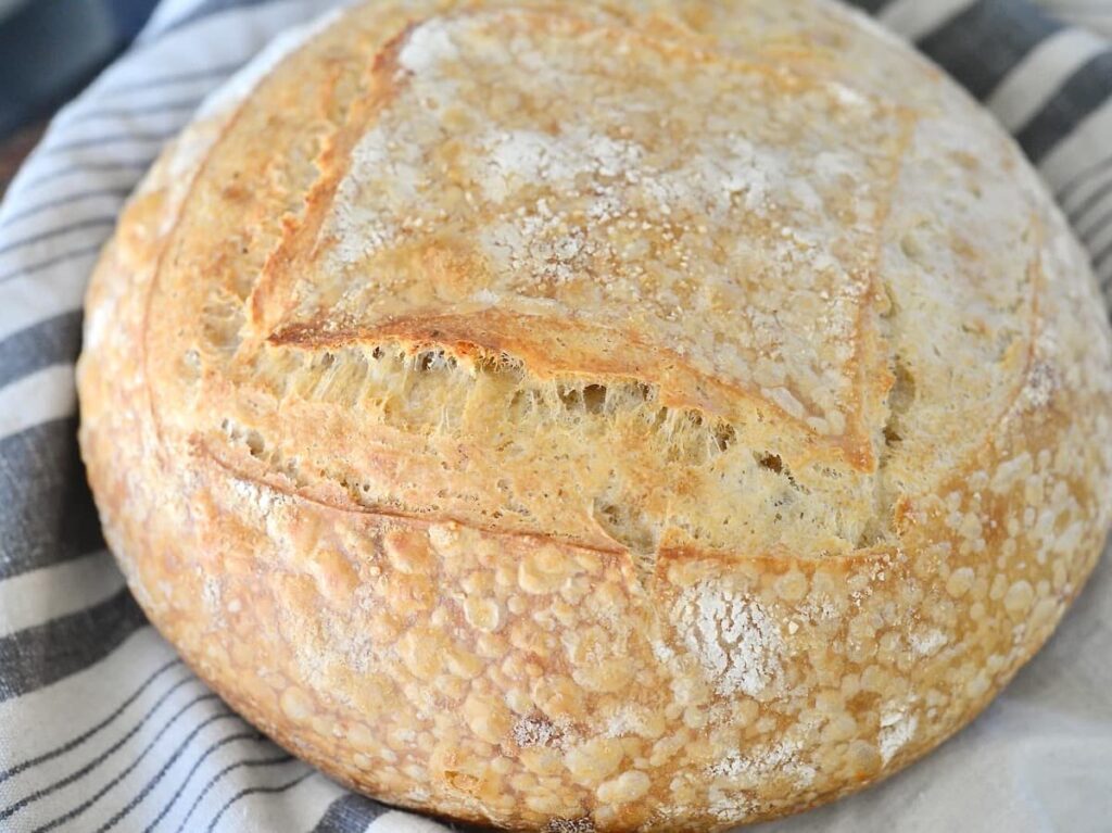 loaf of sourdough bread on kitchen towel