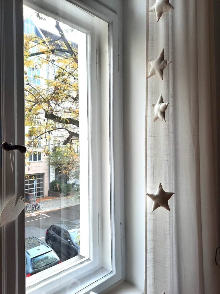 fabric star ornament garland hanging by large window