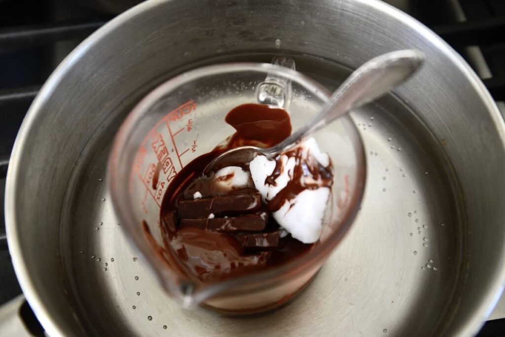 chocolate and coconute butter in glass measuring cup in water bath